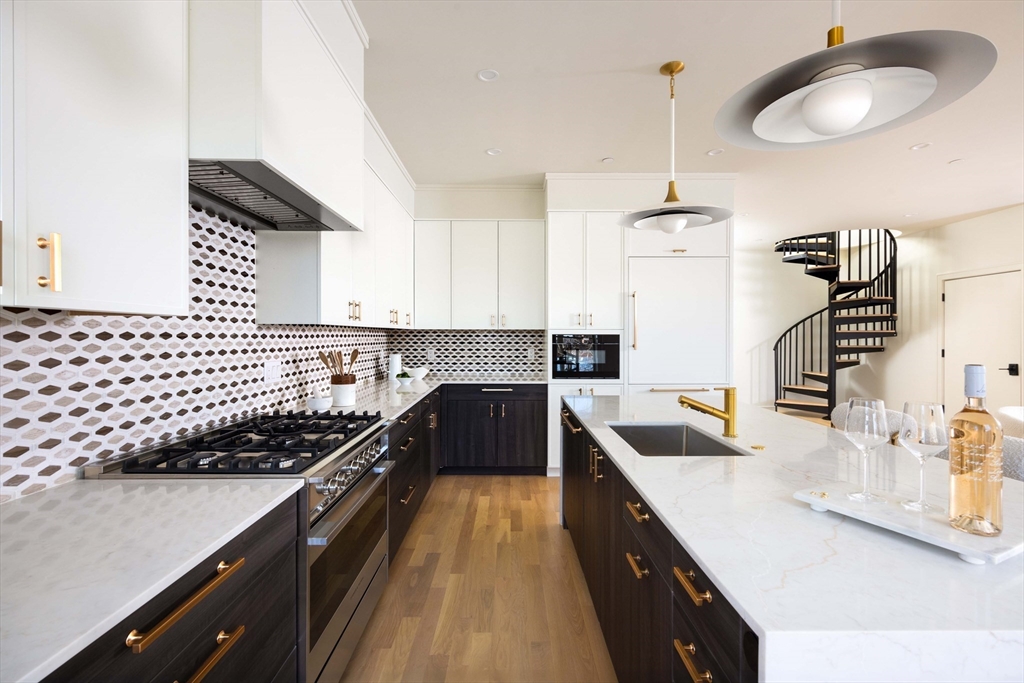 6 Claflin Road, Unit C4 Brookline, MA 02445 - Photo 7 of 23 a kitchen with kitchen island granite countertop a sink a counter space appliances and cabinets