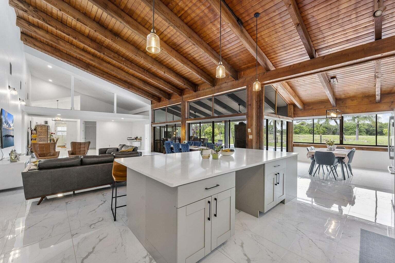 6031 Northwest 4th Avenue Boca Raton, FL 33487 - Photo 8 of 36 a kitchen with a stove a kitchen island with a table and chairs