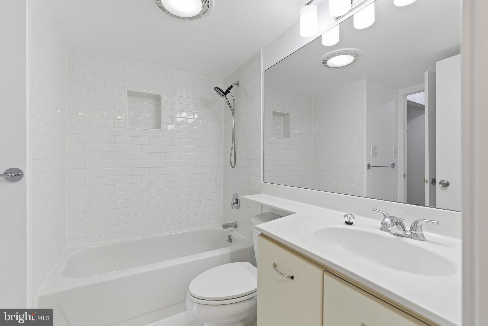 2111 Wisconsin Avenue Northwest, Unit 514 Washington, DC 20007 - Photo 13 of 17 a bathroom with a bathtub shower sink vanity mirror and toilet