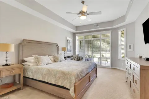 a bedroom with a large bed and a chandelier fan