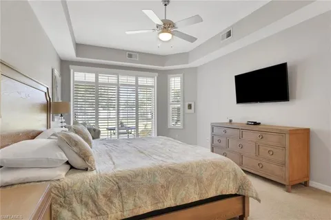 a bedroom with a large bed and a flat screen tv on the dresser