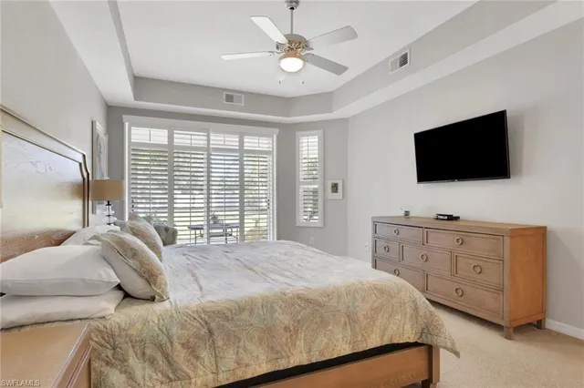 a bedroom with a large bed and a flat screen tv on the dresser