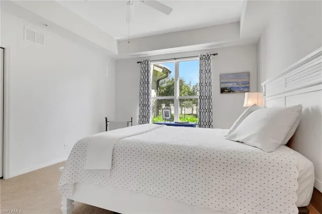 a large bed sitting in a bedroom next to a window