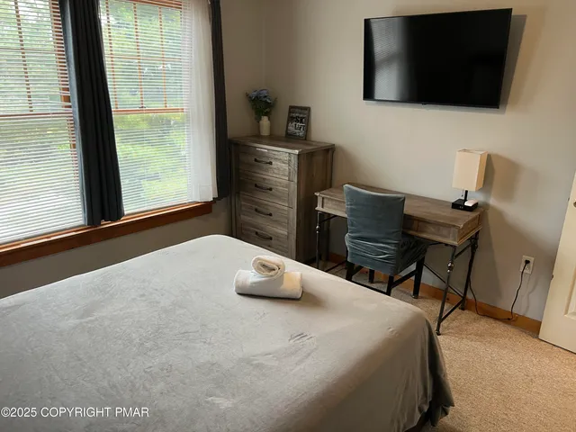 a bedroom with a bed and a flat screen tv