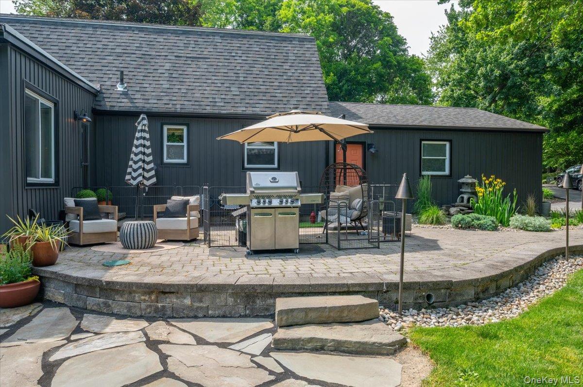 13 Jacks Pond Road Newburgh, NY 12550 - Photo 30 of 44 Beautiful multi-tiered patio showcasing a lower flagstone section and an upper paver patio, accented by a stone retaining wall.
