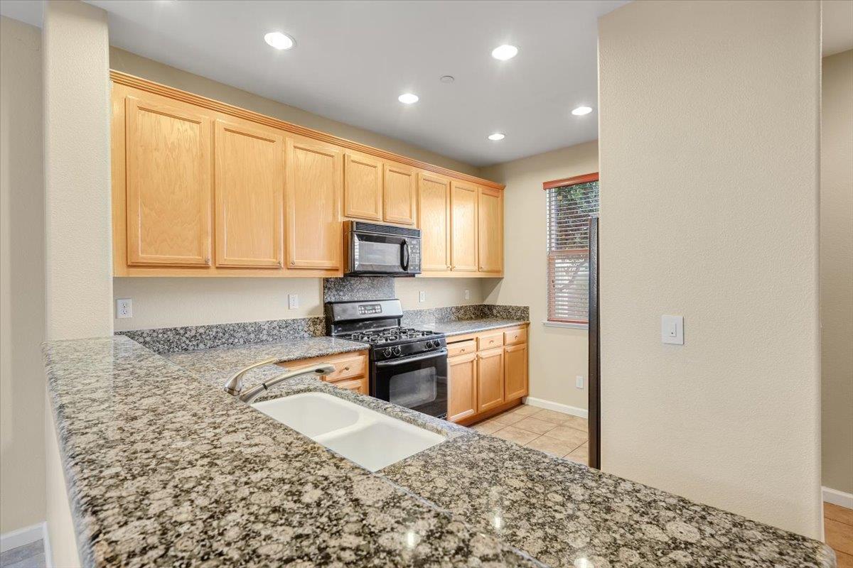 7835 Dickens Way Gilroy, CA 95020 - Photo 3 of 16 a kitchen with granite countertop cabinets stainless steel appliances a sink and a window