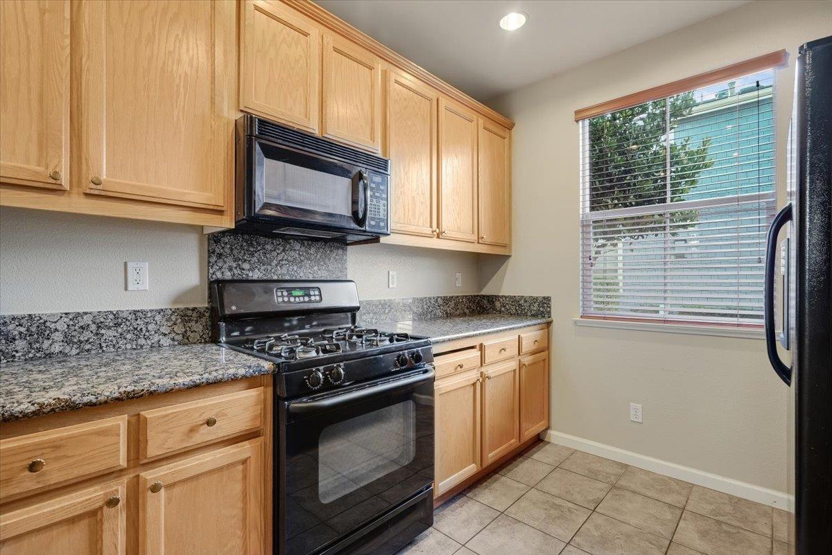 7835 Dickens Way Gilroy, CA 95020 - Photo 4 of 16 a kitchen with granite countertop white cabinets stainless steel appliances and a window