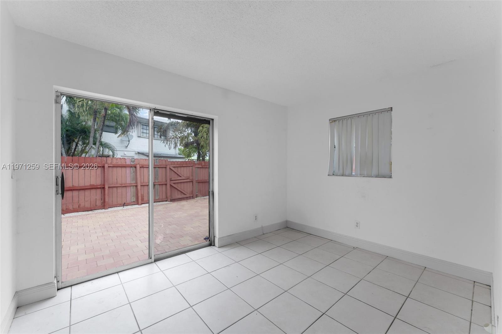 10915 Southwest 71st Street Miami, FL 33173 - Photo 13 of 33 an empty room with sliding glass door