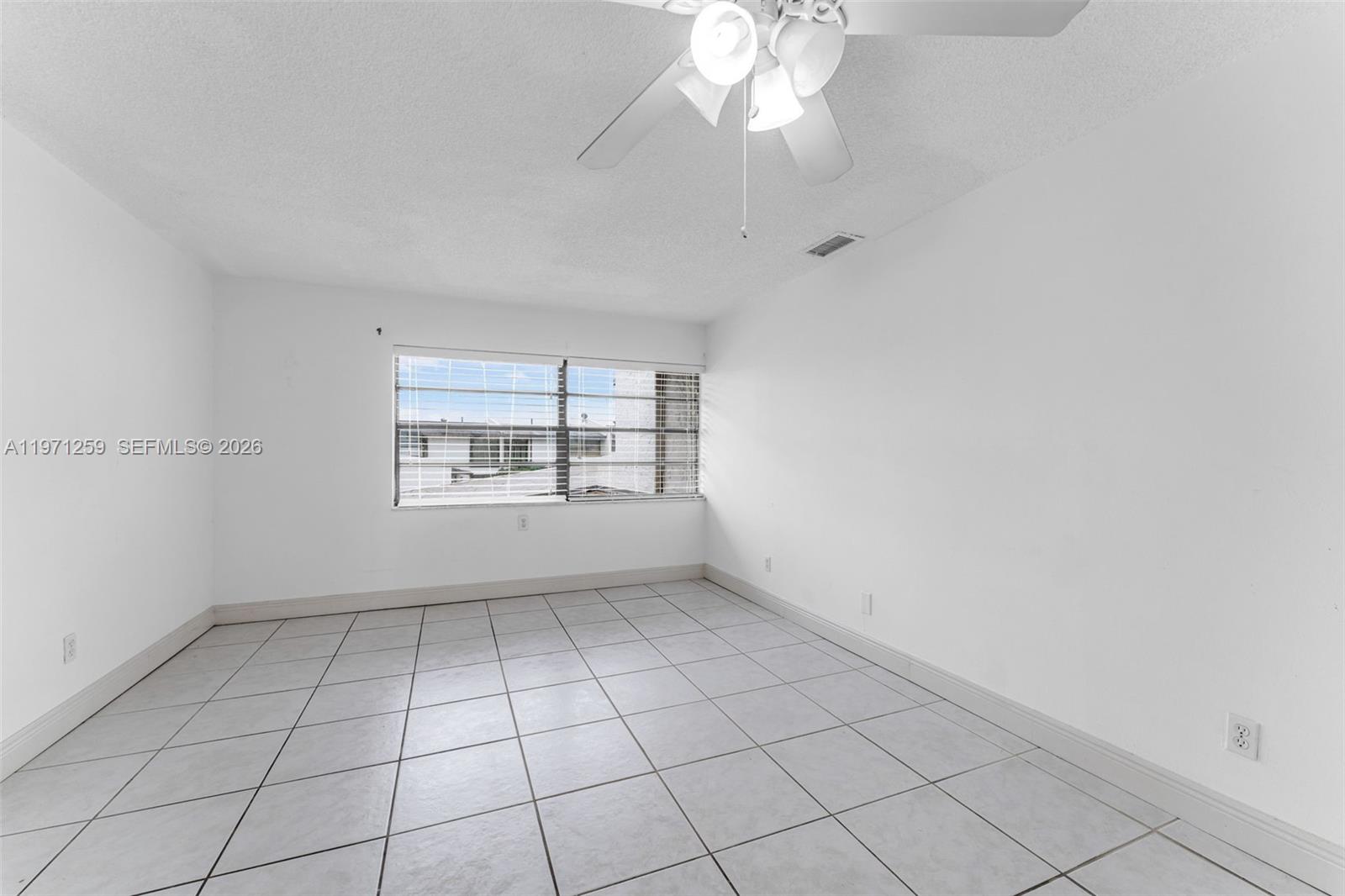 10915 Southwest 71st Street Miami, FL 33173 - Photo 21 of 33 an empty room with windows and fan
