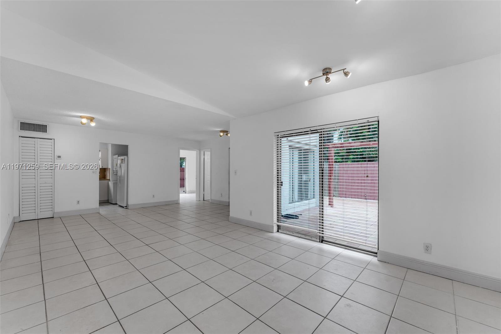 10915 Southwest 71st Street Miami, FL 33173 - Photo 8 of 33 an empty room with entrance and windows