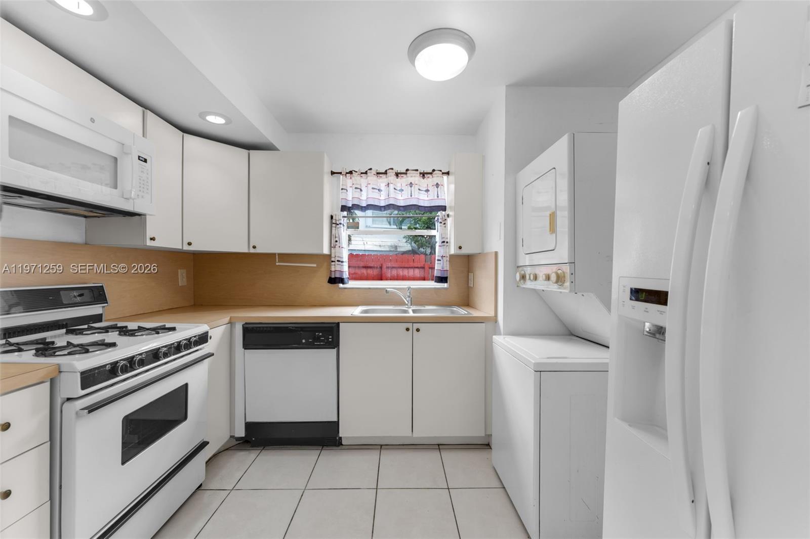 10915 Southwest 71st Street Miami, FL 33173 - Photo 10 of 33 a kitchen with white cabinets and white appliances