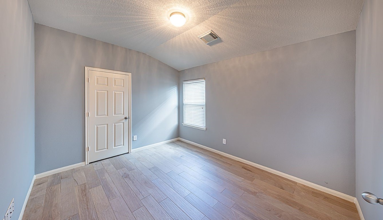 22715 Imperial Ivy Court Spring, TX 77373 - Photo 20 of 45 an empty room with wooden floor and windows