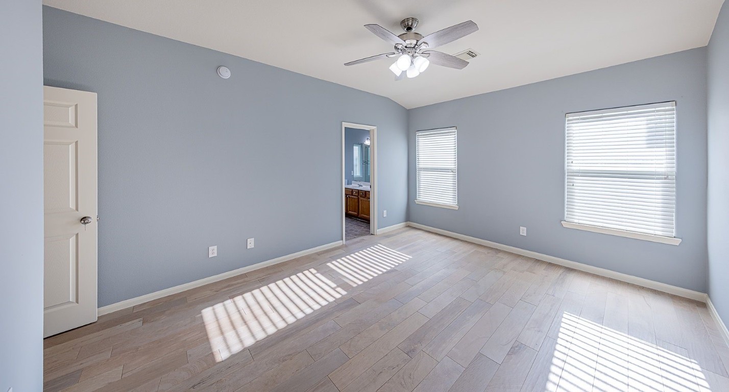 22715 Imperial Ivy Court Spring, TX 77373 - Photo 23 of 45 a view of an empty room with chandelier fan and wooden floor