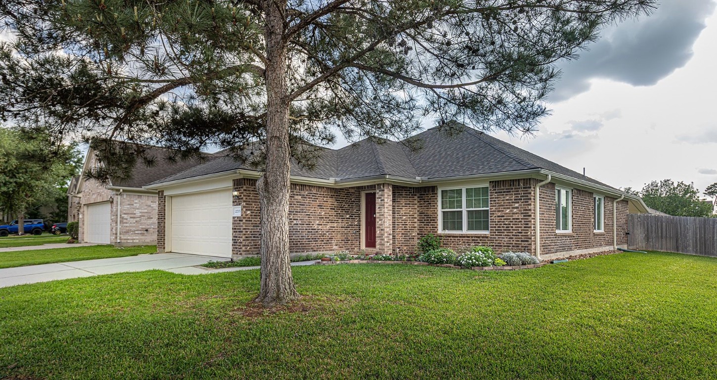 22715 Imperial Ivy Court Spring, TX 77373 - Photo 3 of 45 a front view of a house with a yard and large tree