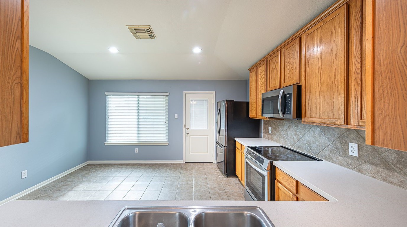 22715 Imperial Ivy Court Spring, TX 77373 - Photo 32 of 45 a kitchen with stainless steel appliances granite countertop a refrigerator a stove top oven a sink and dishwasher