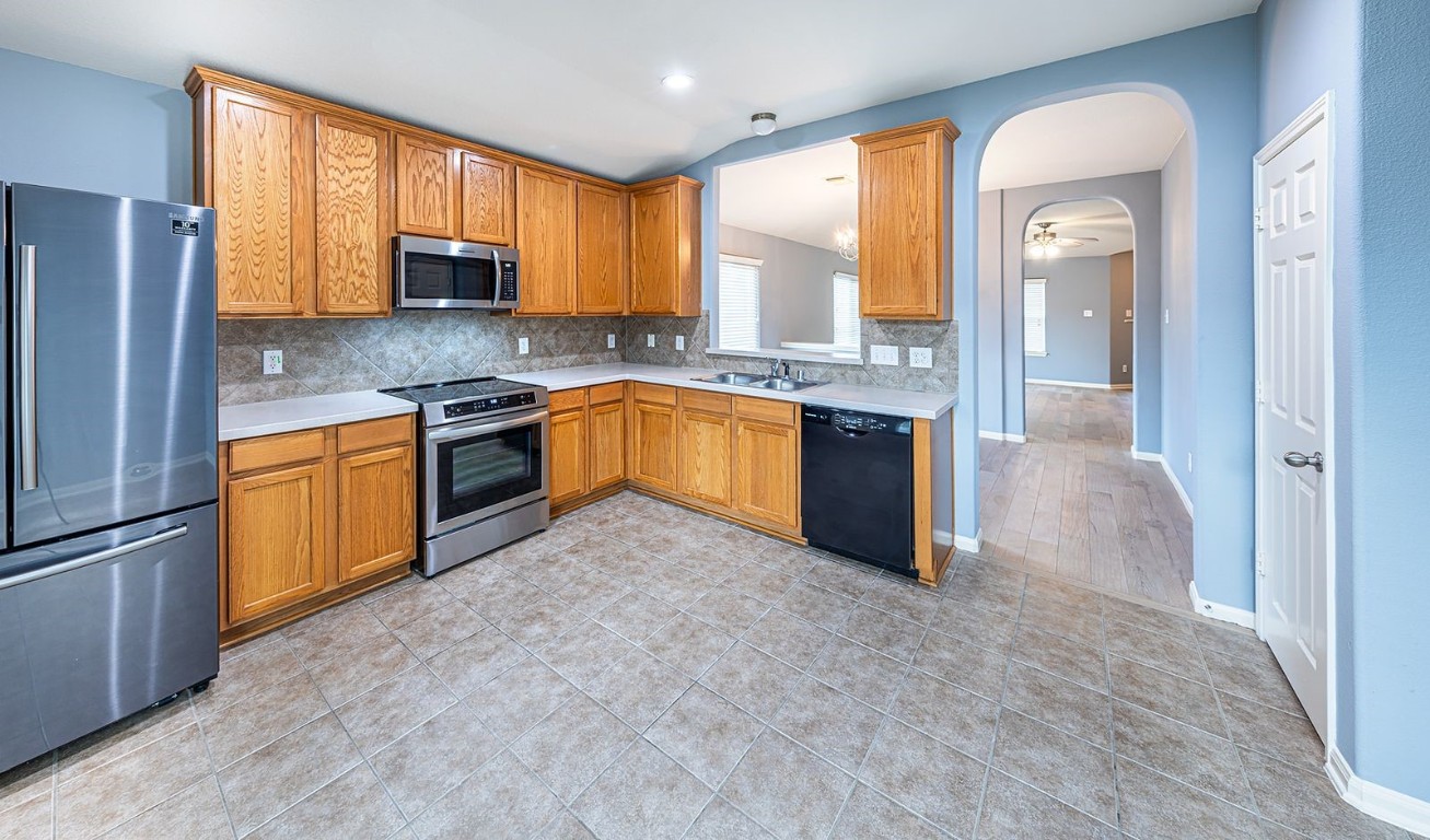 22715 Imperial Ivy Court Spring, TX 77373 - Photo 33 of 45 a large kitchen with stainless steel appliances granite countertop a stove a sink and a refrigerator