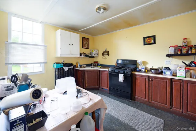 a kitchen with a table chairs a stove a window and dining table