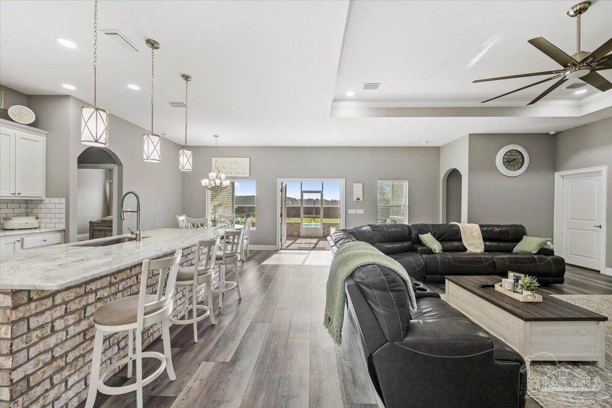 9258 Roy Cook Road Pace, FL 32571 - Photo 16 of 63 a living room with furniture a large window and stainless steel appliances