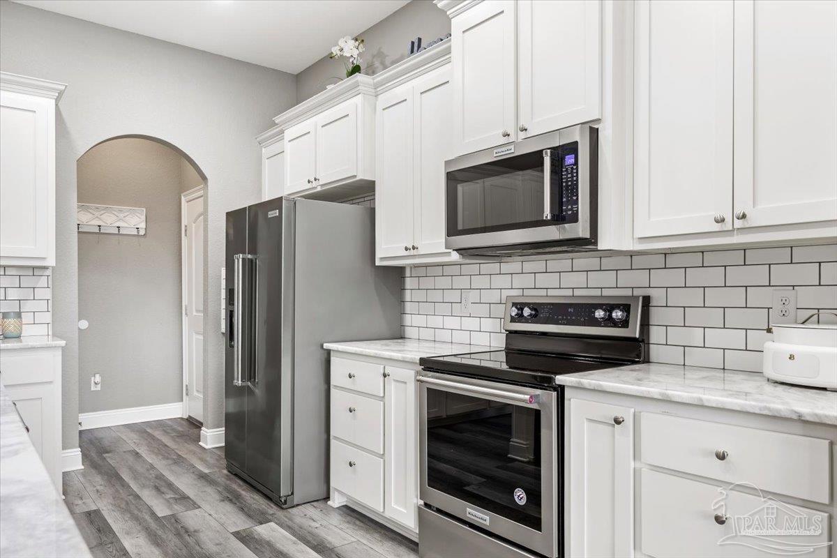 9258 Roy Cook Road Pace, FL 32571 - Photo 22 of 63 a kitchen with stainless steel appliances a stove a refrigerator a sink and cabinets