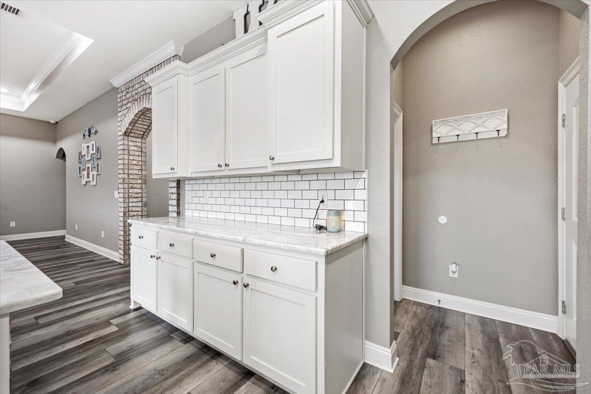 9258 Roy Cook Road Pace, FL 32571 - Photo 25 of 63 a kitchen with granite countertop white cabinets and white appliances