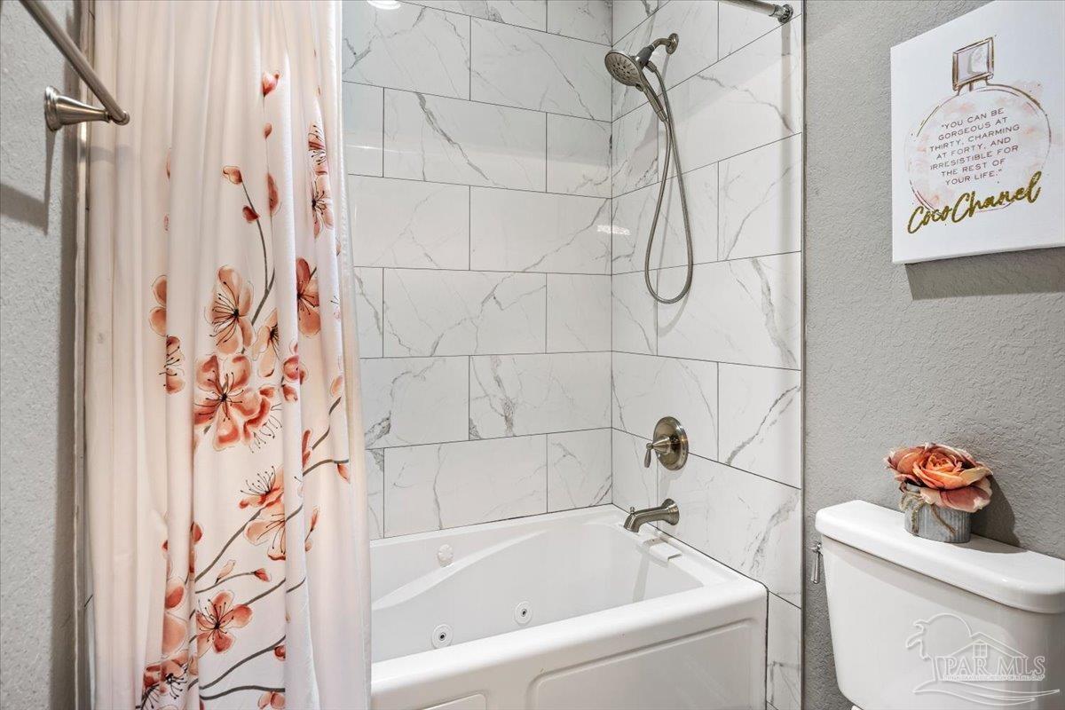 9258 Roy Cook Road Pace, FL 32571 - Photo 40 of 63 a bathroom with a bathtub and shower