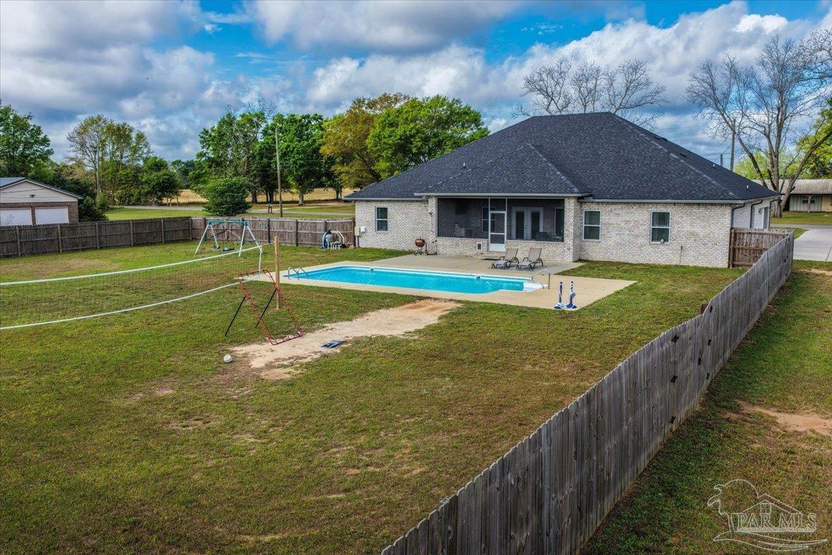 9258 Roy Cook Road Pace, FL 32571 - Photo 53 of 63 a view of a house with pool and a yard