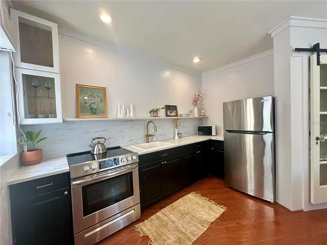 a kitchen with stainless steel appliances granite countertop a refrigerator sink and stove