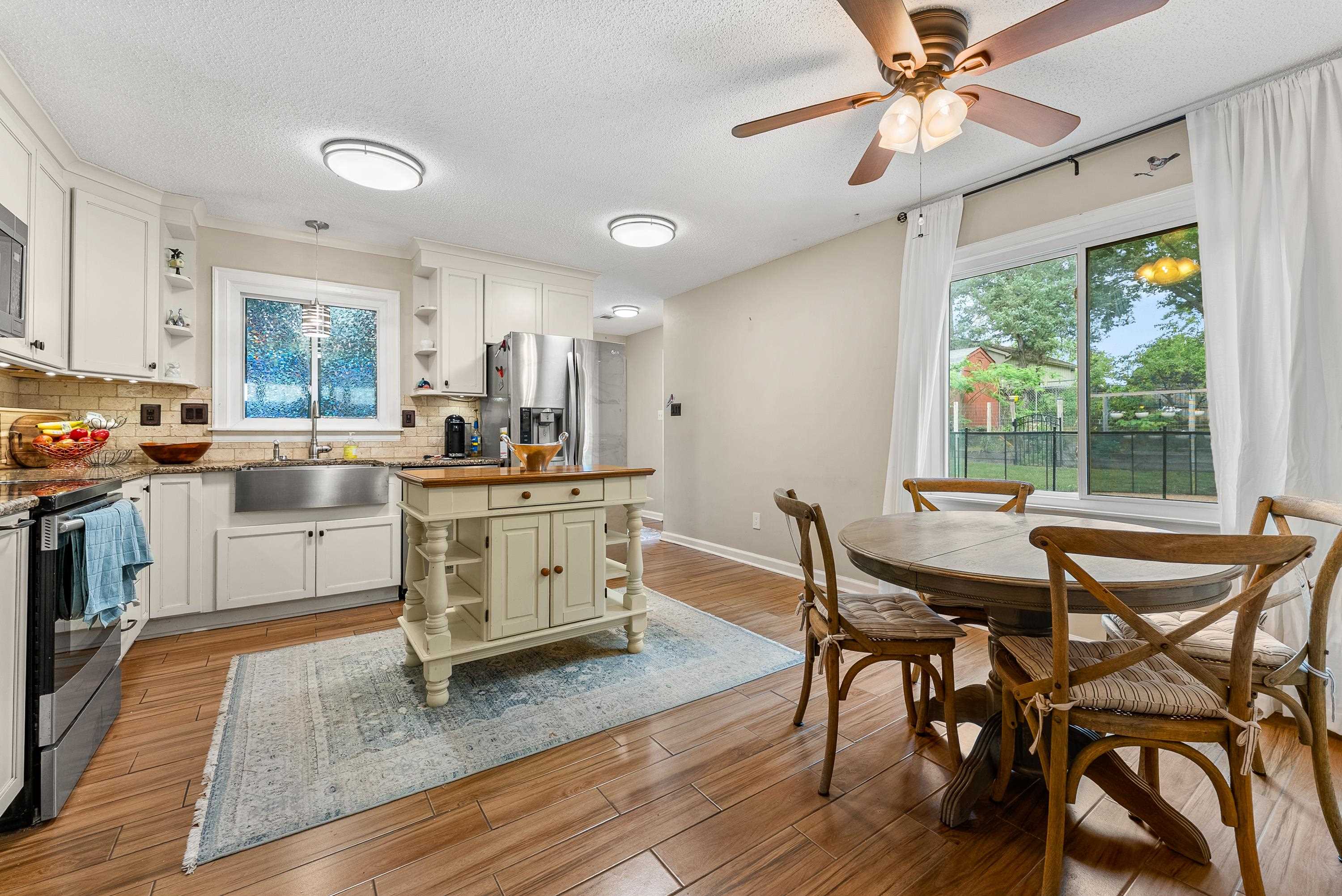 182 East Powell Road Collierville, TN 38017 - Photo 4 of 21 a kitchen with stainless steel appliances kitchen island wooden floors and white cabinets