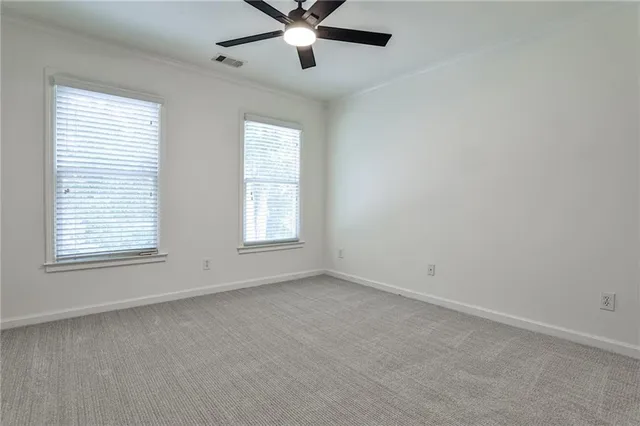 an empty room with a window and a fan