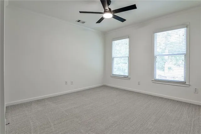 an empty room with a window and a fan