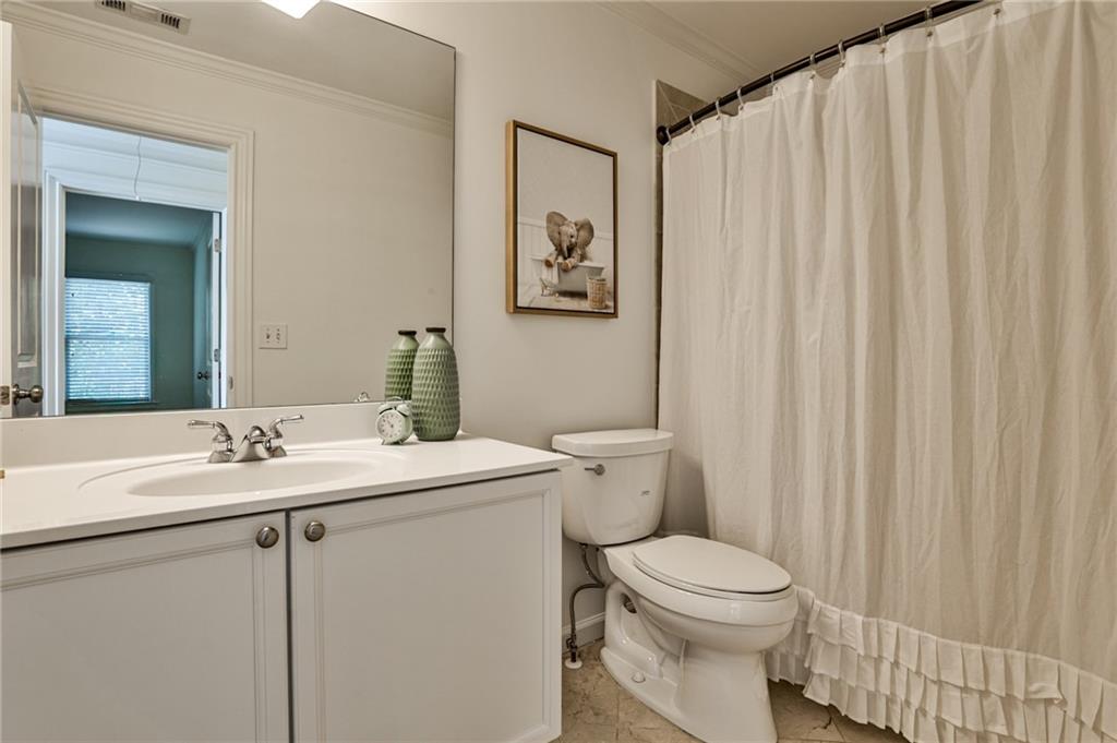 1621 Duncan Drive Northwest Atlanta, GA 30318 - Photo 26 of 53 a bathroom with a sink a toilet and a mirror