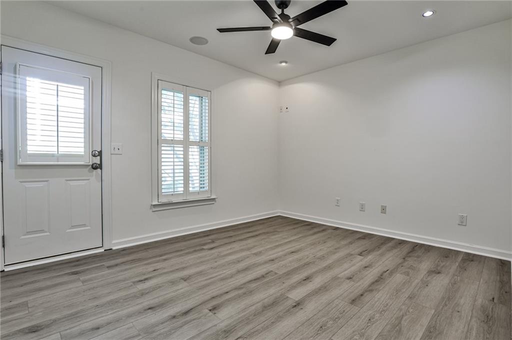 1621 Duncan Drive Northwest Atlanta, GA 30318 - Photo 28 of 53 an empty room with wooden floor fan and windows