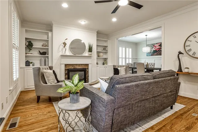 a living room with furniture a fireplace and a chandelier