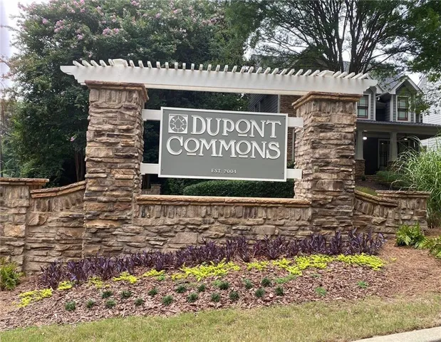 a front view of a house with a garden and tree