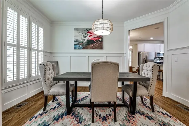 a view of a dining room with furniture a chandelier and wooden floor