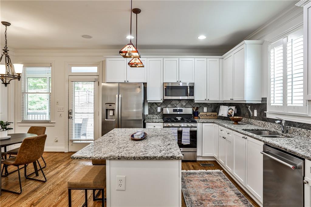 1621 Duncan Drive Northwest Atlanta, GA 30318 - Photo 9 of 53 a kitchen with stainless steel appliances granite countertop a sink a stove a refrigerator cabinets and living room view