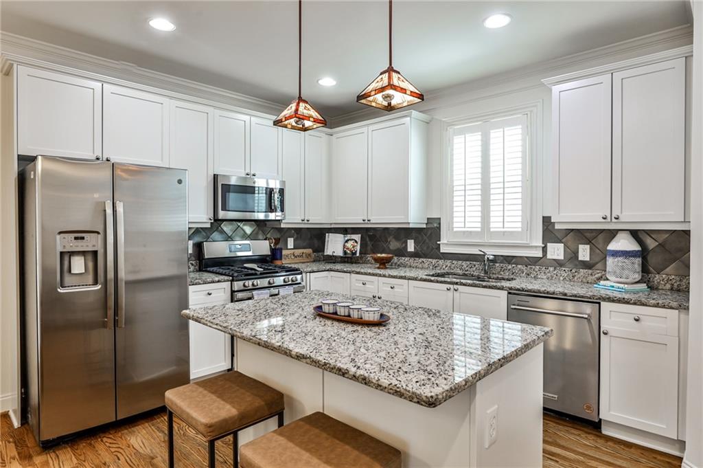 1621 Duncan Drive Northwest Atlanta, GA 30318 - Photo 10 of 53 a kitchen with kitchen island granite countertop stainless steel appliances a sink stove a refrigerator a center island and cabinets