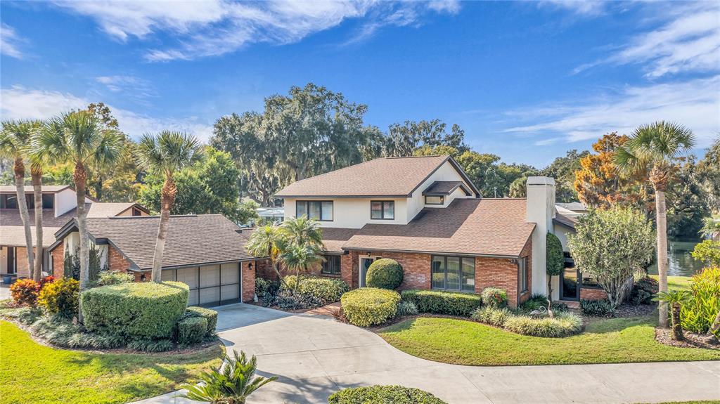 104 Acacia Point Yalaha, FL 34797 - Photo 2 of 83 a view of a big house with a big yard and potted plants