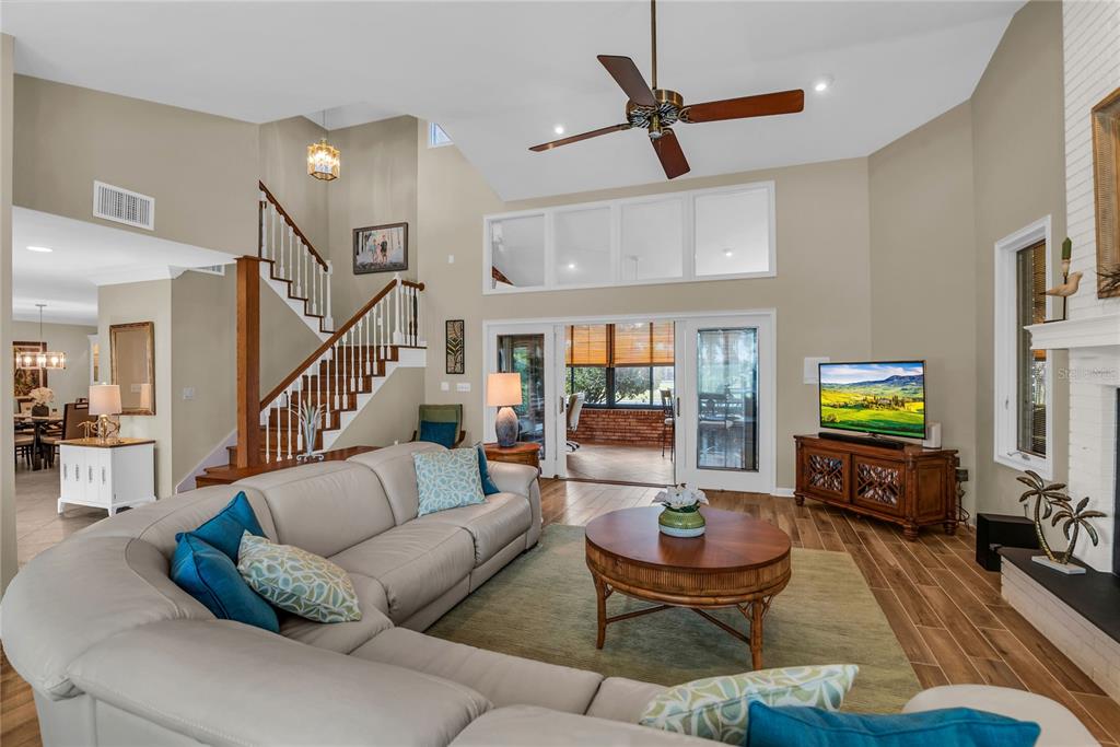 104 Acacia Point Yalaha, FL 34797 - Photo 5 of 83 a living room with furniture ceiling fan and a wooden floor
