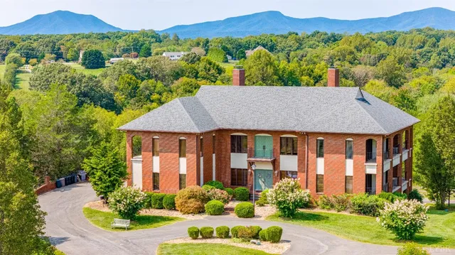 a front view of a house with a yard and potted plants