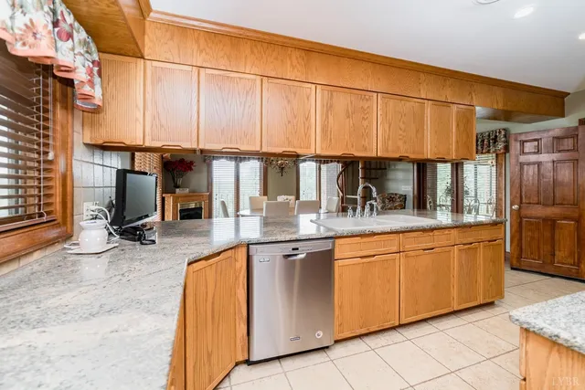 a view of a house with a yard and table and chairs in patio