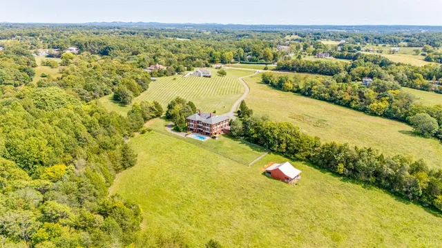 a view of a large house with a big yard and large trees