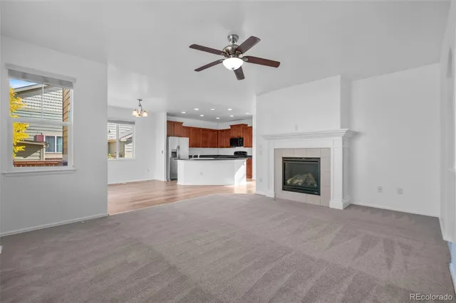 a view of a livingroom with a ceiling fan and a fireplace