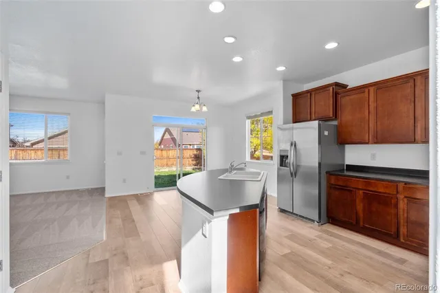 a kitchen with stainless steel appliances granite countertop a refrigerator a sink and a stove