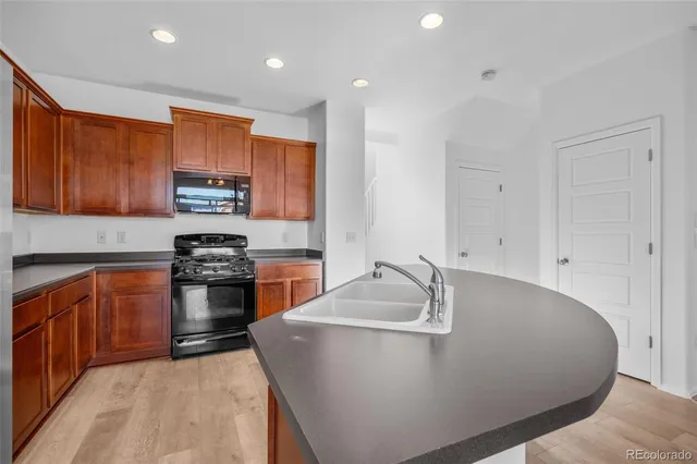 a kitchen with stainless steel appliances granite countertop a sink a stove and a refrigerator