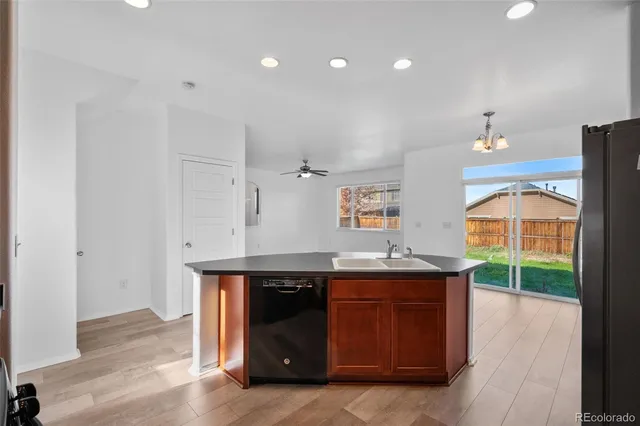 a kitchen with kitchen island granite countertop a sink and a stove