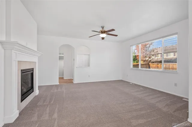 a view of an empty room with a fireplace and a window