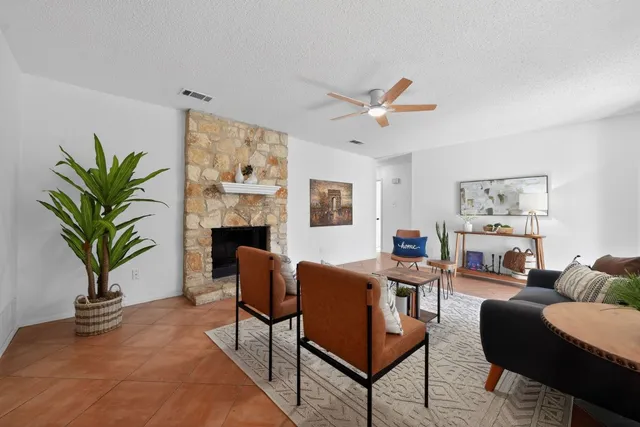 a living room with furniture a fireplace and a potted plant