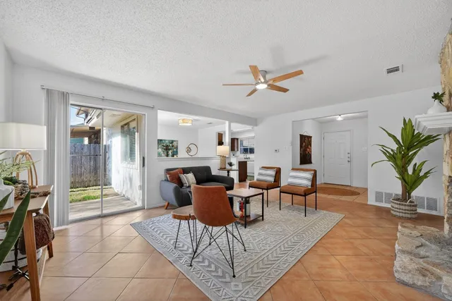 a living room with furniture a ceiling fan and a rug
