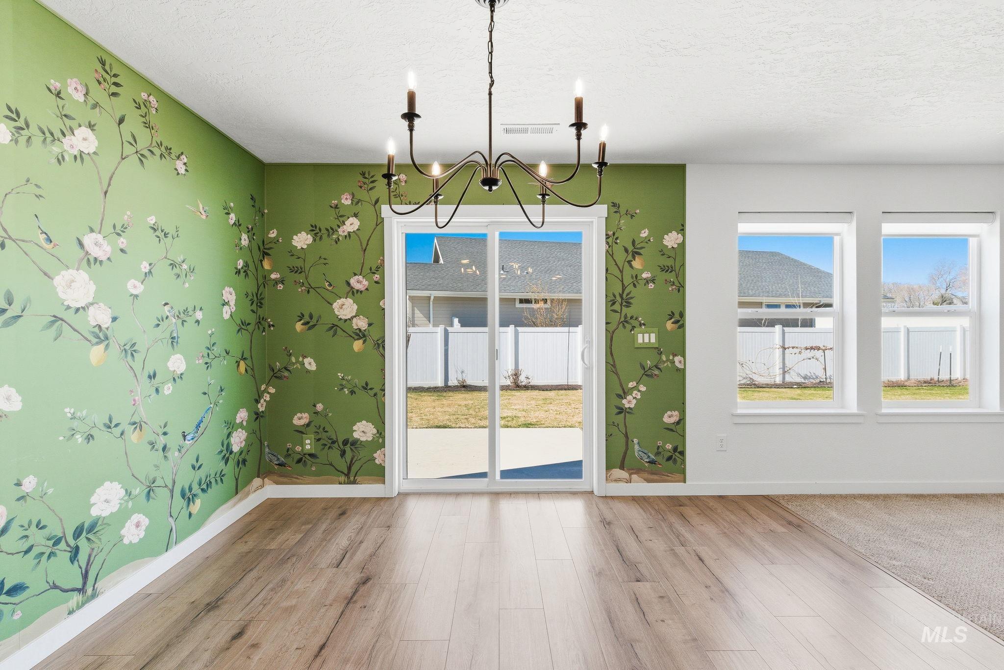 110 Homesteaders Street Middleton, ID 83644 - Photo 13 of 49 Unfurnished dining area featuring suspended lighting, light wood-type flooring, and a textured ceiling